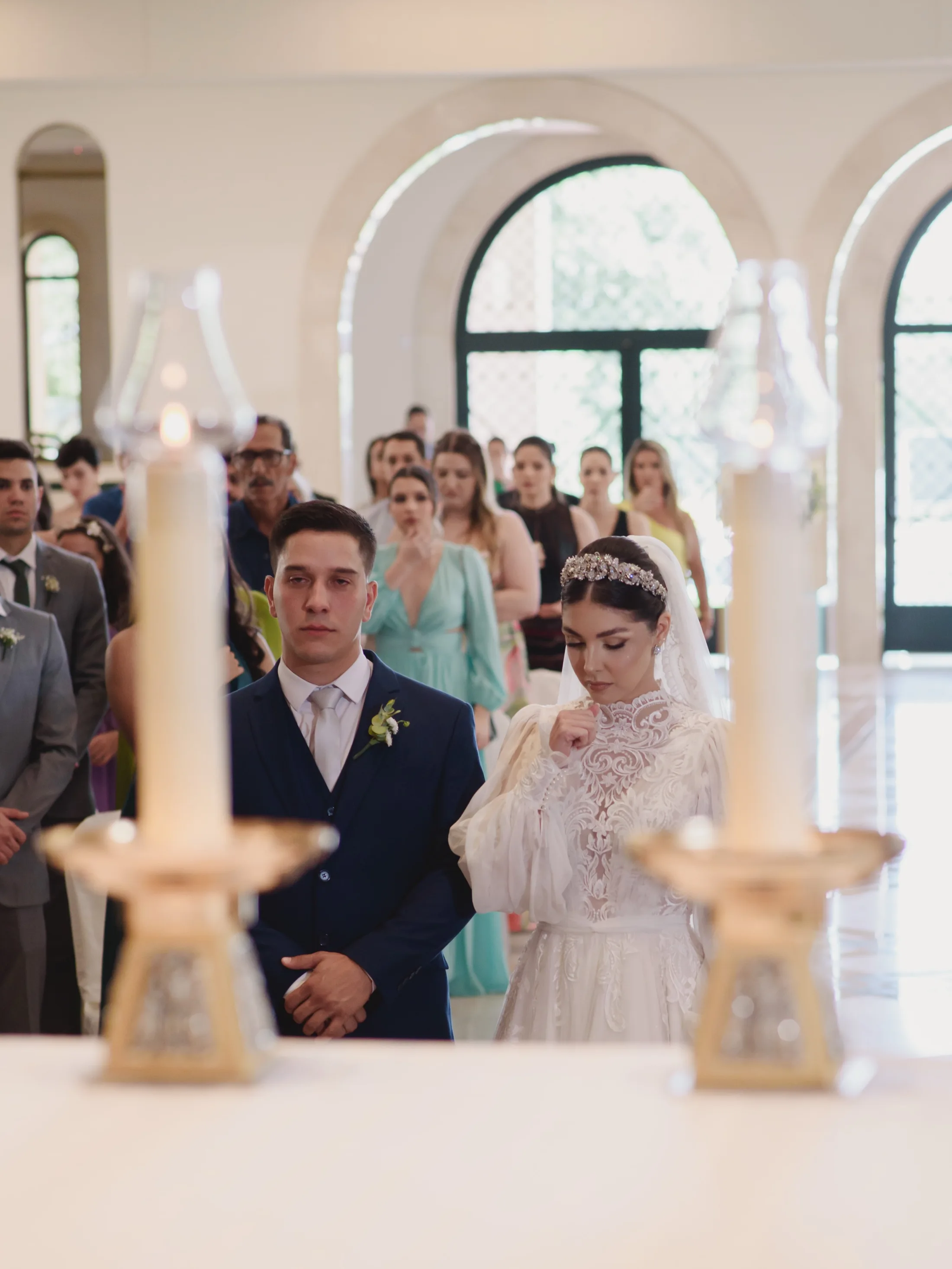 Casal de noivos em frente aos convidados na igreja.