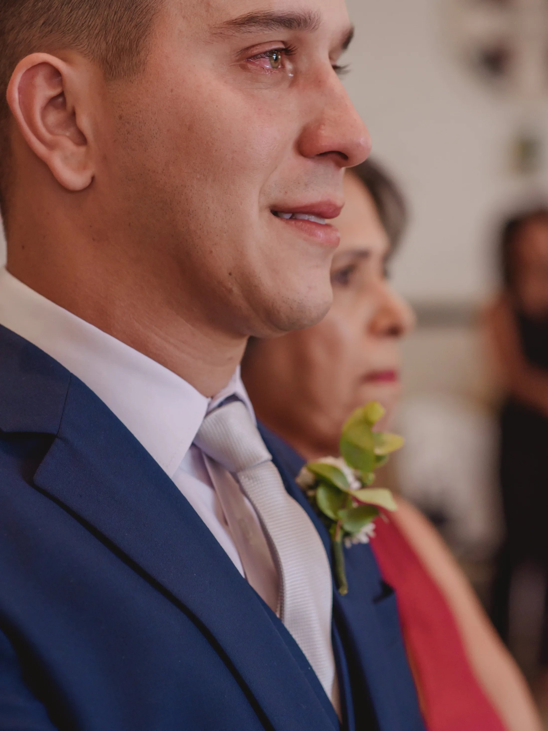 Noivo sorrindo, com uma lágrima no rosto.