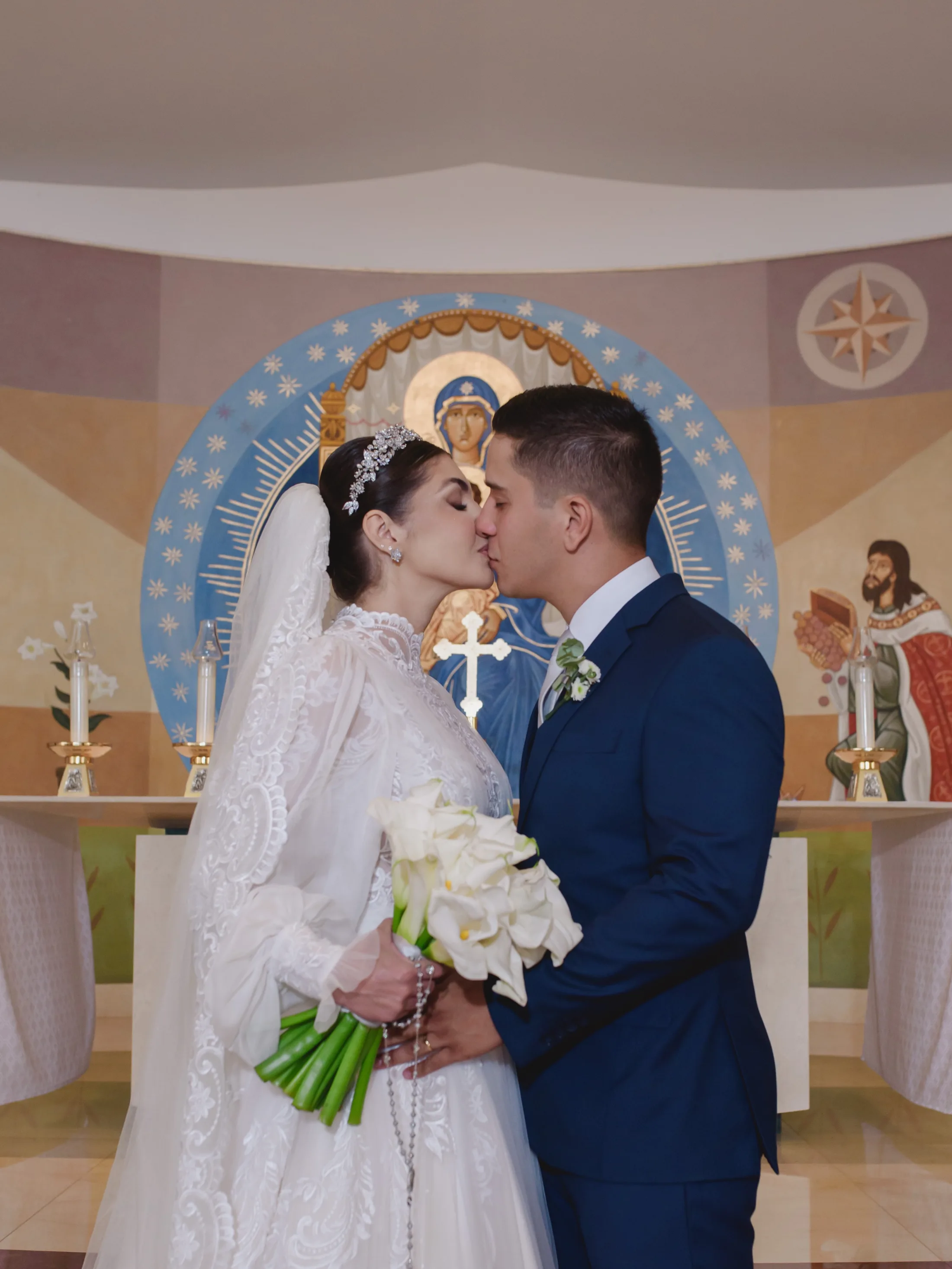 Noivos se beijando diante do altar.